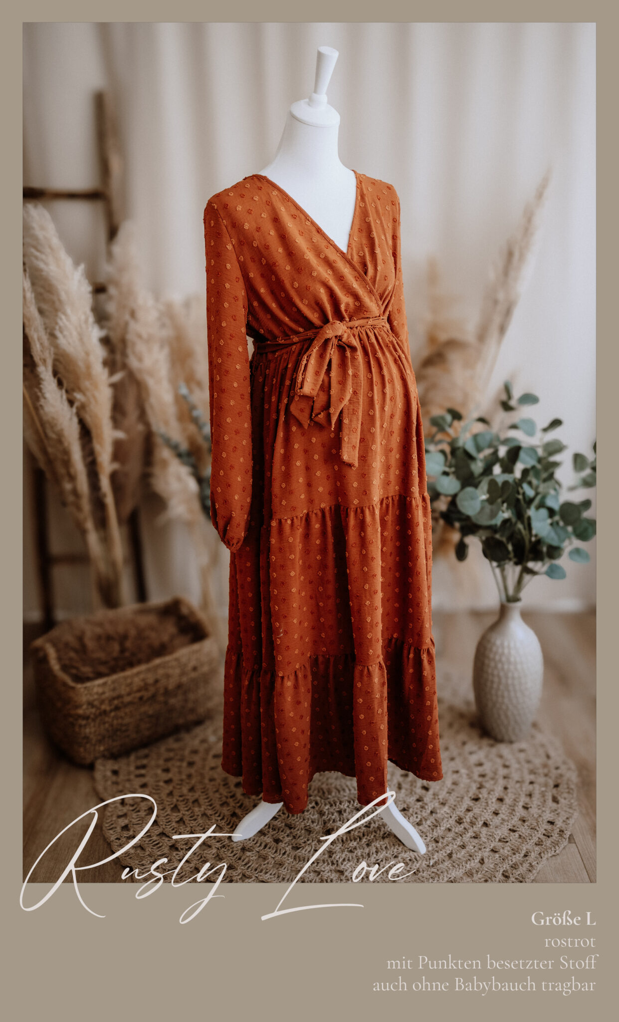 Ein rostfarbenes, langärmeliges, gepunktetes Umstandskleid wird auf einer Schaufensterpuppe ausgestellt. Die Szene zeigt Pampasgras, einen geflochtenen Korb und eine Vase mit Eukalyptus auf einem gemütlichen, neutral getönten Hintergrund. Der Text überlagert das Bild.